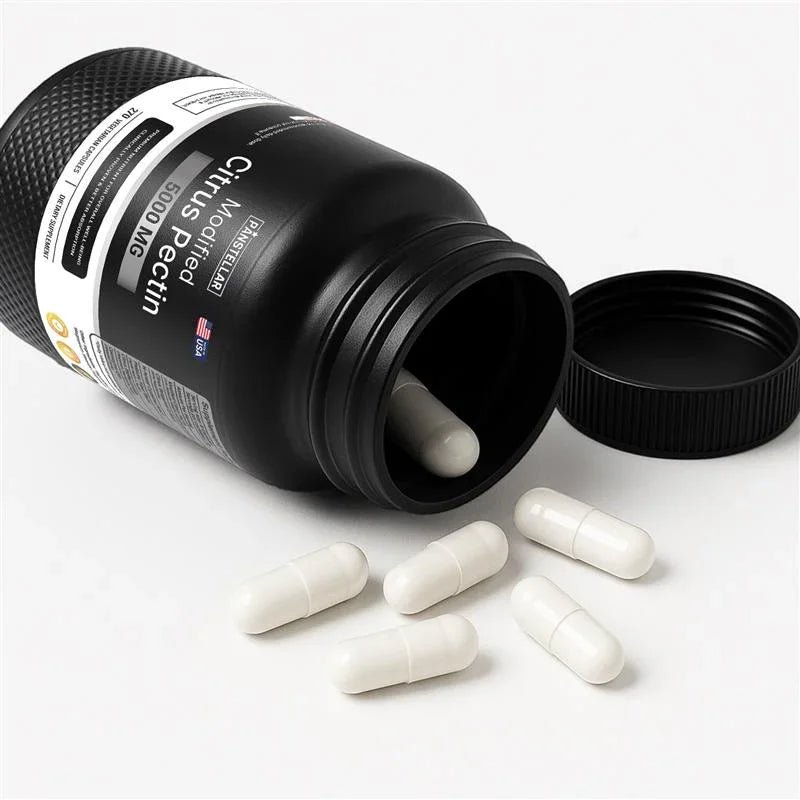 Modified citrus pectin supplement capsules spilling from black bottle on white background